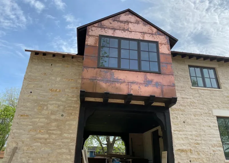 Copper metal panel facade on a stone building for Skylight Installation in Volney